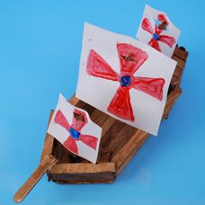 two paper boats with red and blue designs on them