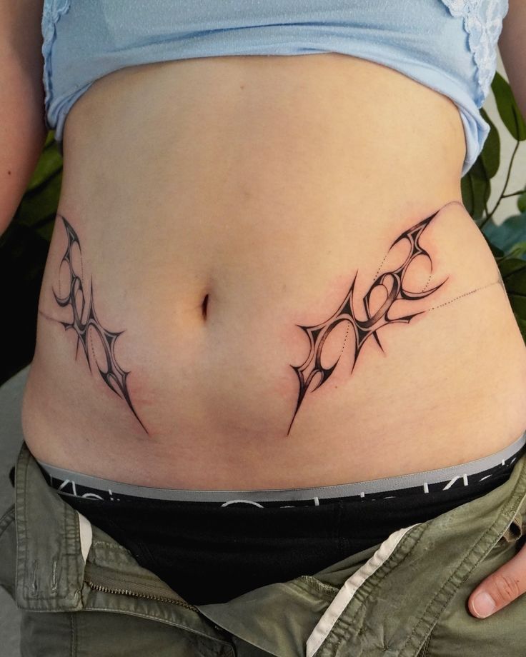 a woman's stomach with tattoos on it