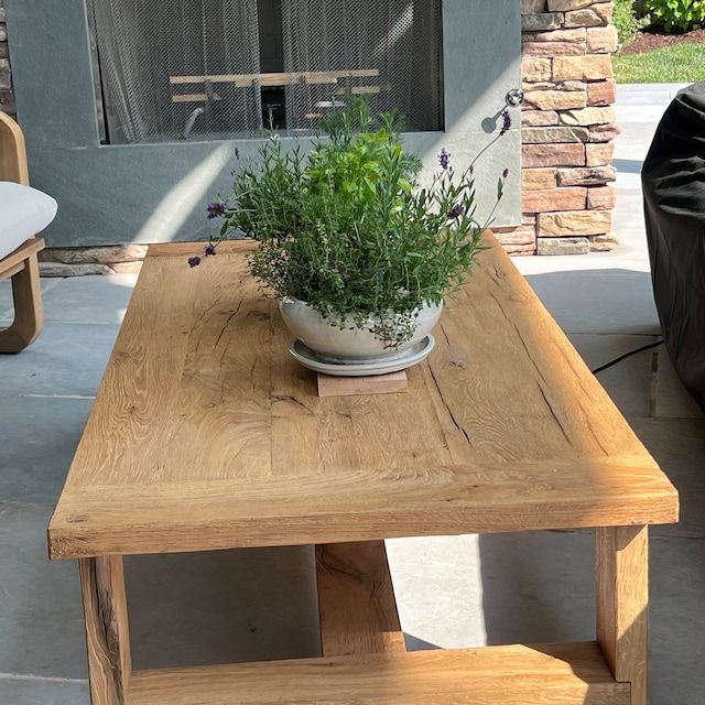 a potted plant sitting on top of a wooden table next to a fire place