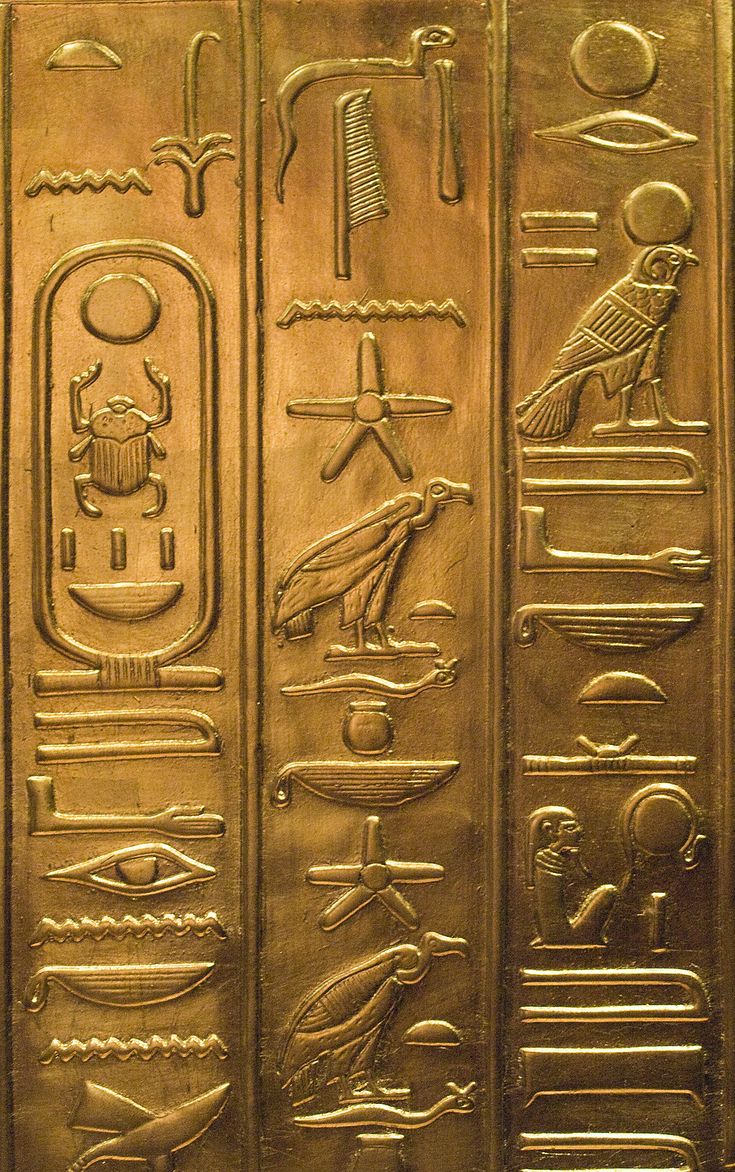 an egyptian gold panel with hieroglyphics and symbols