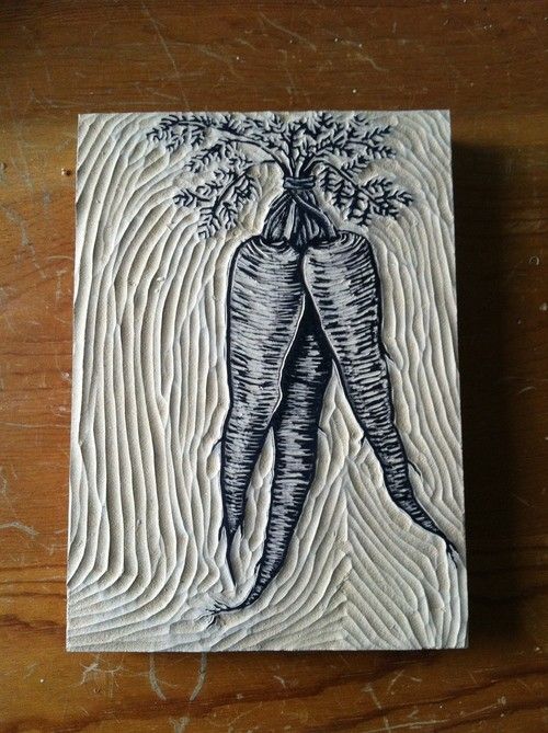 two carrots are depicted on a wooden surface