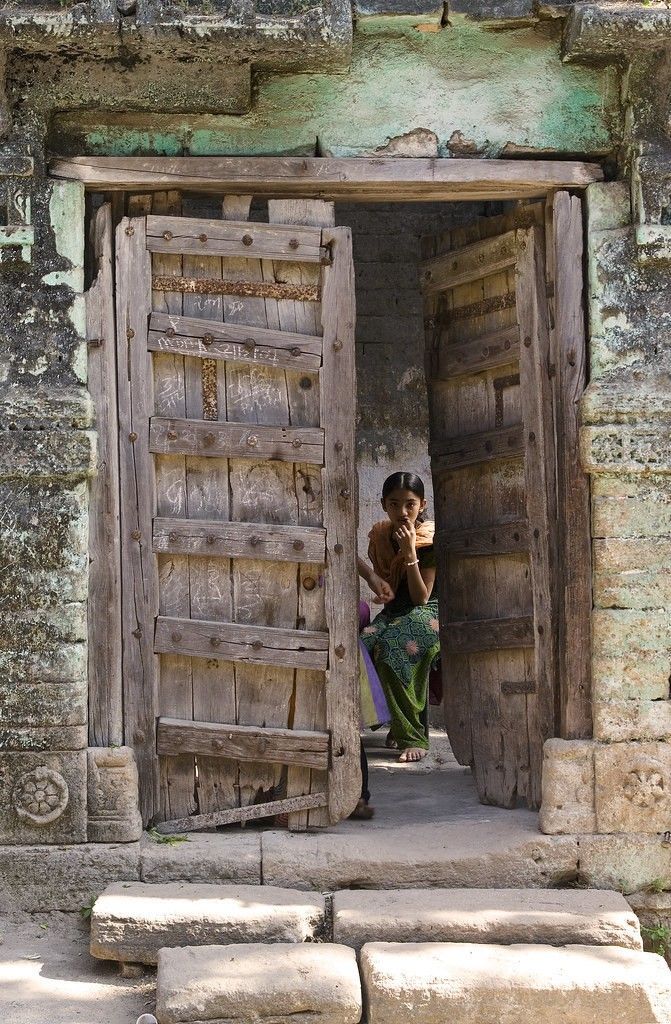 a woman standing in an open doorway to a building