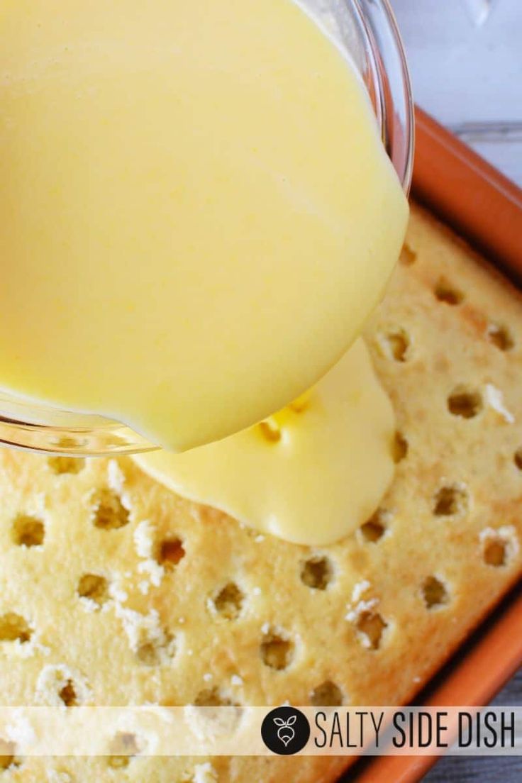 a person pours cheese into a glass bowl on top of a cracker tray