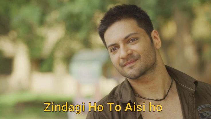 a man in brown shirt smiling at the camera with trees and grass behind him that reads, zindagi ho to aisi ho