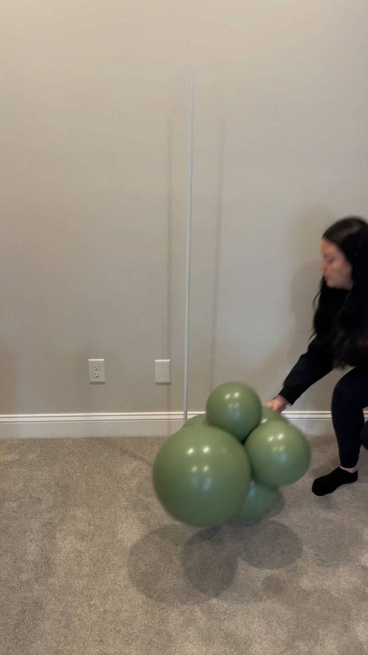 a woman is playing with some balls on the floor