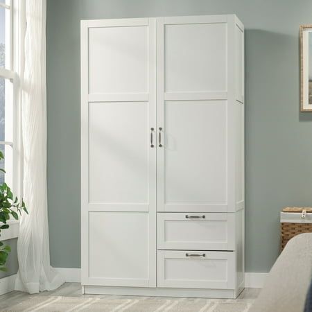 a white armoire with drawers in a room