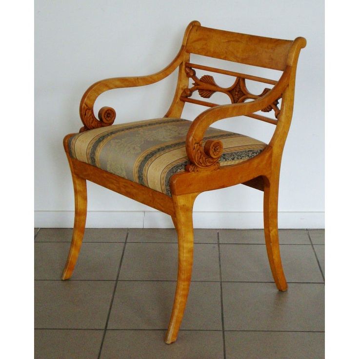 a wooden chair sitting on top of a tiled floor