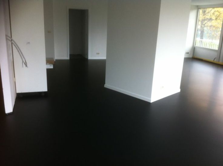 an empty room with black floors and white walls