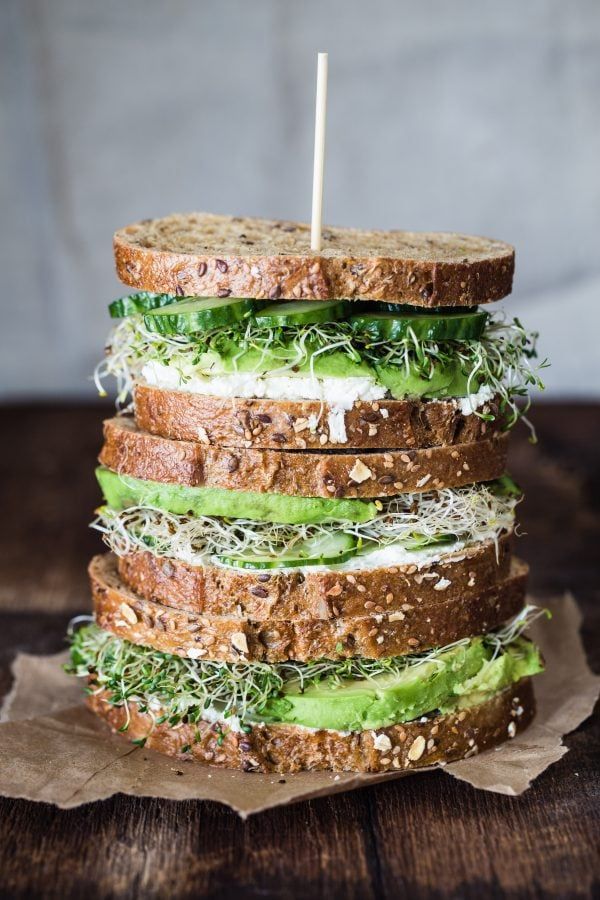 a stack of sandwiches with lettuce, cheese and other toppings on top