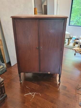 a wooden cabinet sitting on top of a hard wood floor