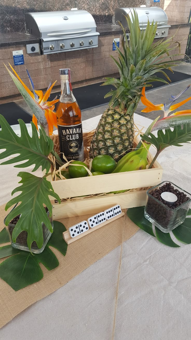 pineapples, bananas, and other fruit are in a crate on a table