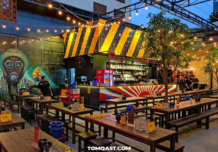 the interior of a restaurant with tables, benches and lights hanging from the ceiling above