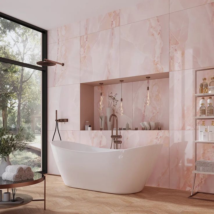 a bathroom with pink marble walls and flooring, including a freestanding bathtub