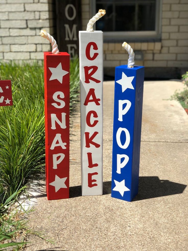 two red, white and blue signs that say cracky pop on the side of a sidewalk