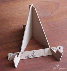 an origami triangle is sitting on a wooden table