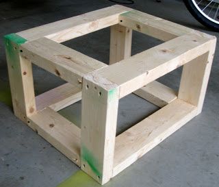 a wooden box sitting on the ground next to a bicycle tire rack and some green tape