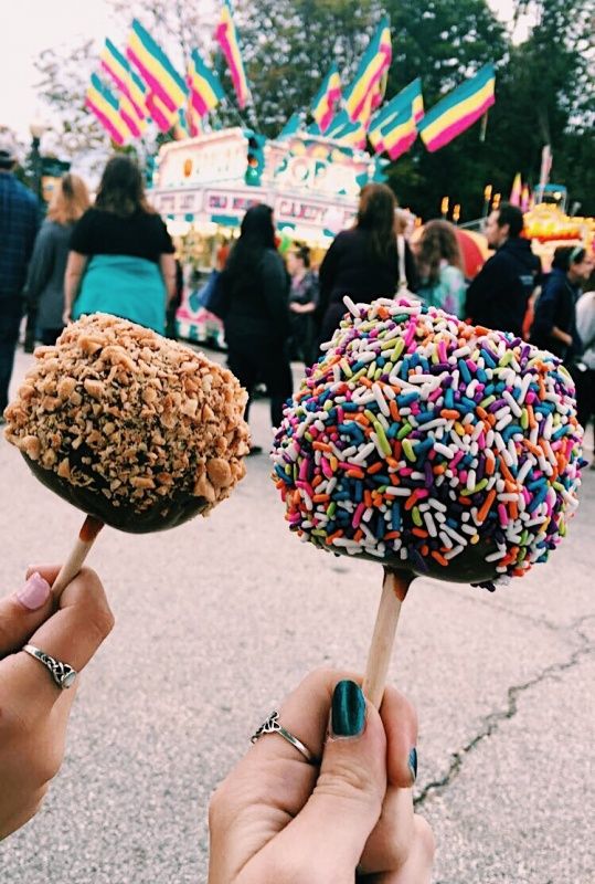 two lollipops with sprinkles on them being held by someone