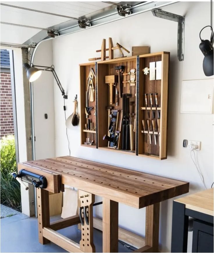 a workbench with many tools in it and some lights on the wall behind it