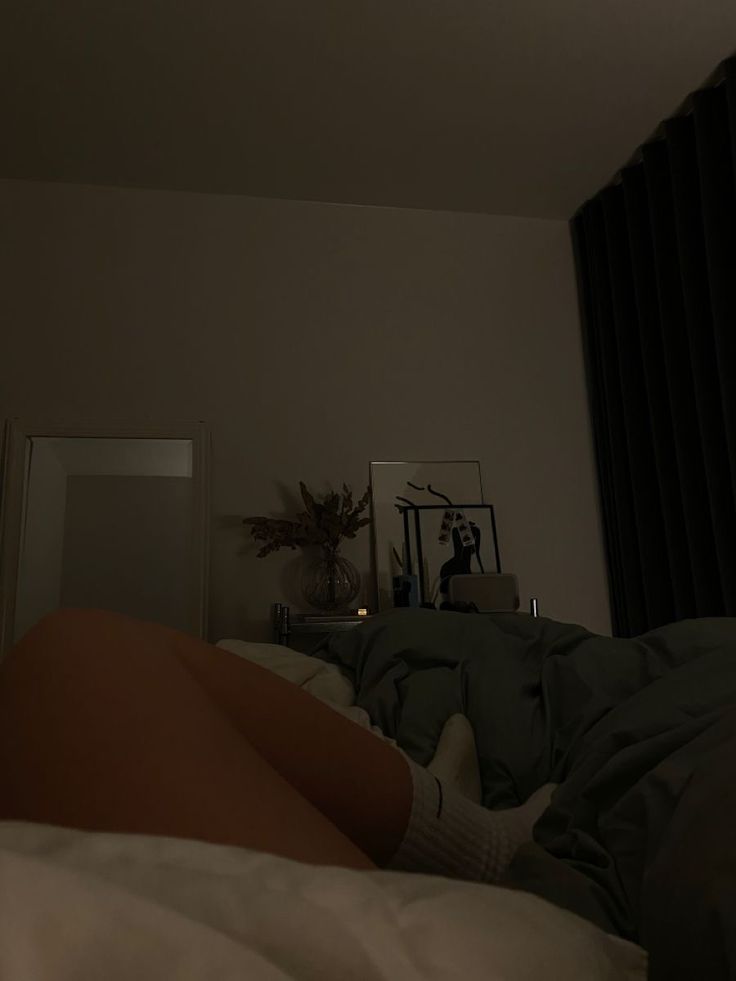 a woman laying in bed with her legs crossed