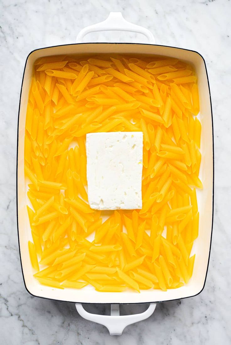 cheese and butter in a white dish on a marble surface