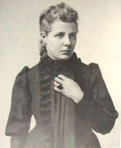 an old black and white photo of a woman wearing a dress with ruffles