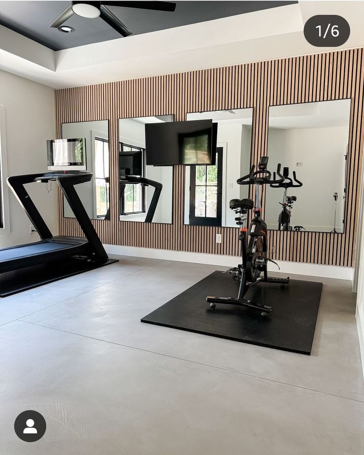 there is a gym room with mirrors and exercise equipment on the floor in front of it