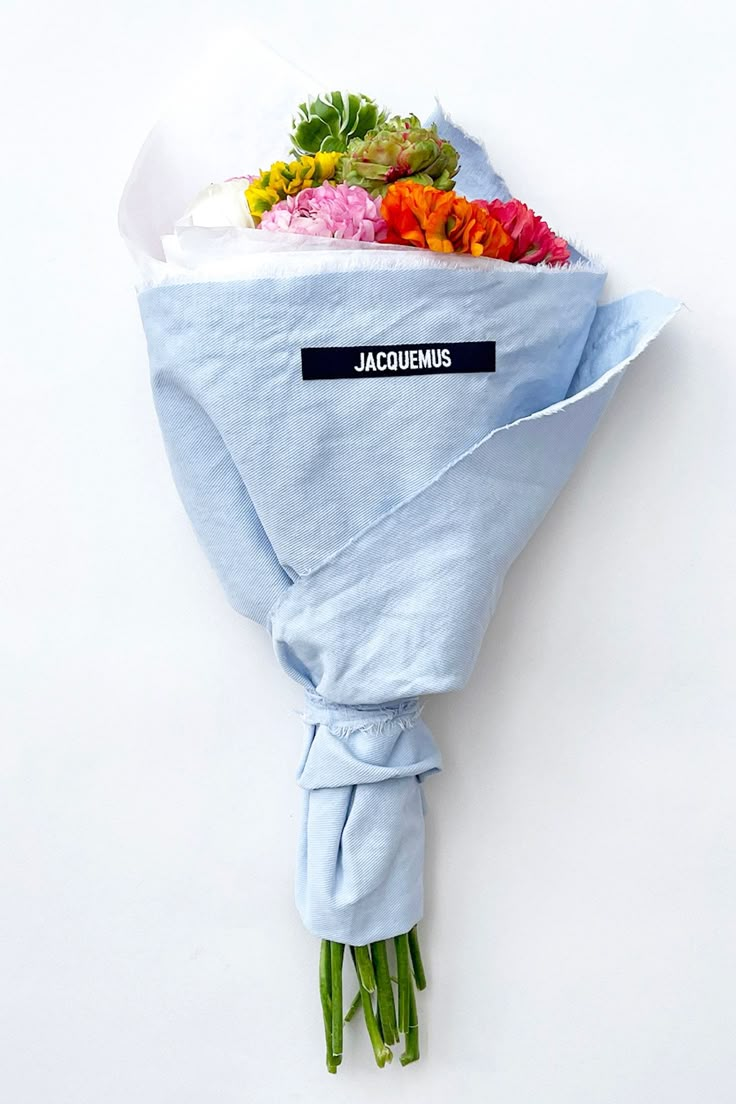 a bouquet of flowers wrapped in blue paper