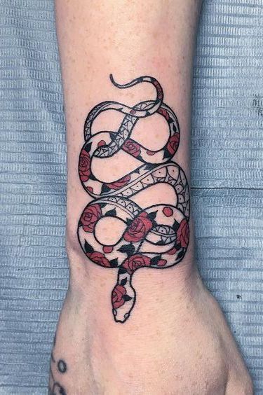 a snake tattoo on the wrist is shown in black and red colors, with an intricate design