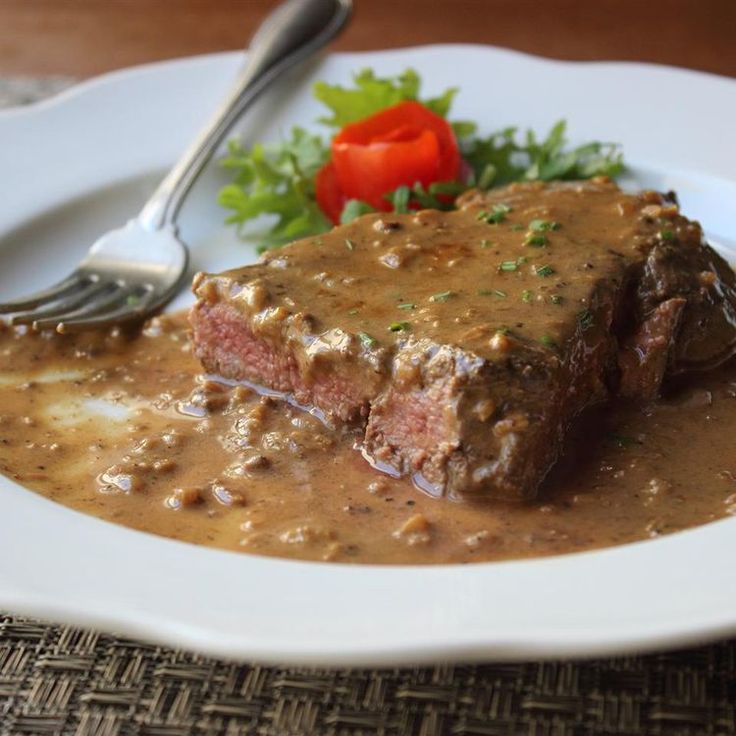 a white plate topped with meat and gravy