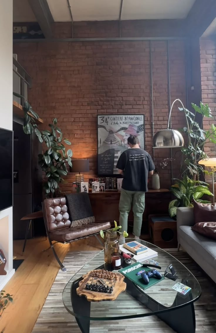 a man standing in the middle of a living room next to a couch and coffee table