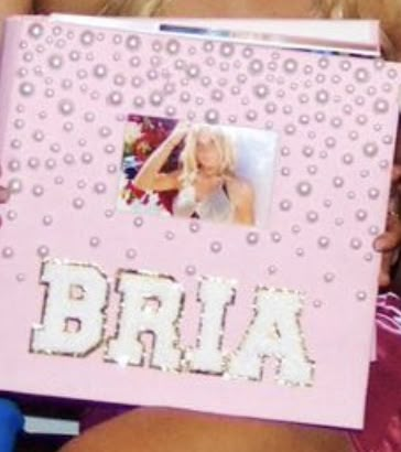 a woman holding up a pink album with the word bria on it