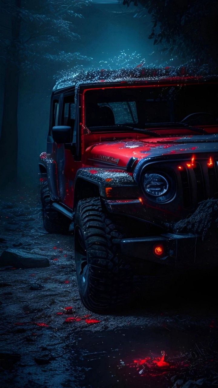 a red jeep parked in the woods at night