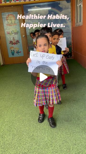 two children holding up signs in front of a classroom door that says healthier habitats, happier lives get up early i'm the other times