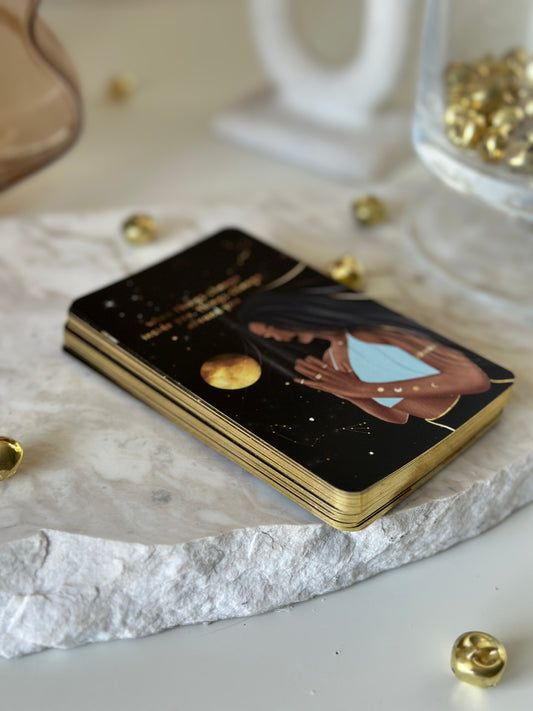 a gold and black notebook sitting on top of a white table next to some glass vases