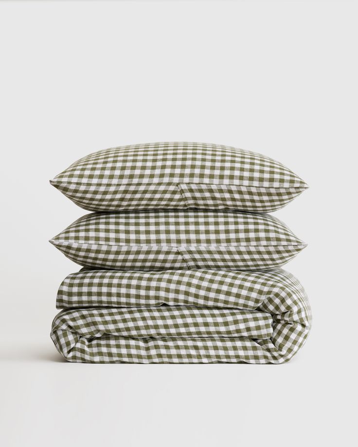 four pillows stacked on top of each other in green and white gingham fabric