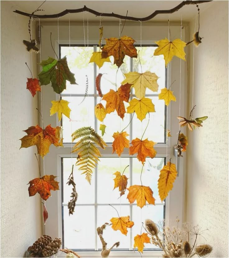 a window sill filled with lots of autumn leaves and branches hanging from it's side