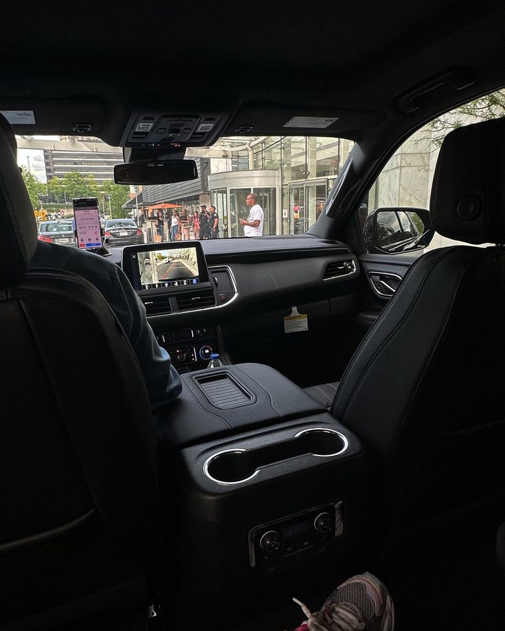 the interior of a vehicle with people walking by in the distance and on the street