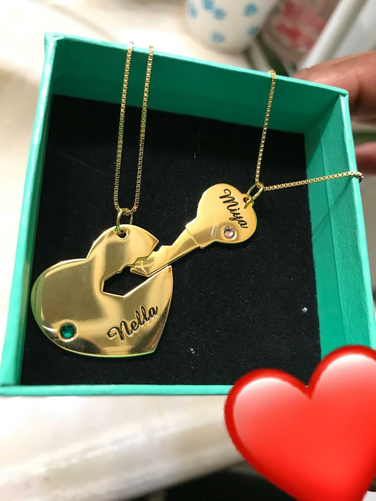 a personalized gold guitar necklace in a green box with a red heart on the table