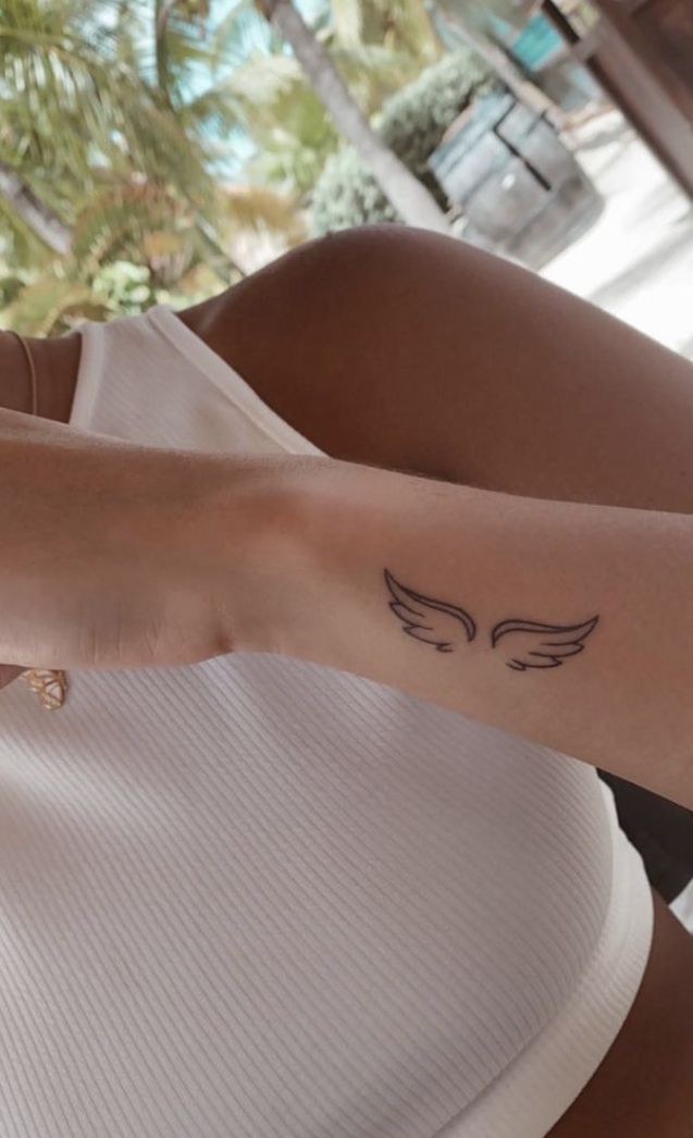 a woman's arm with a small tattoo on the left side of her body