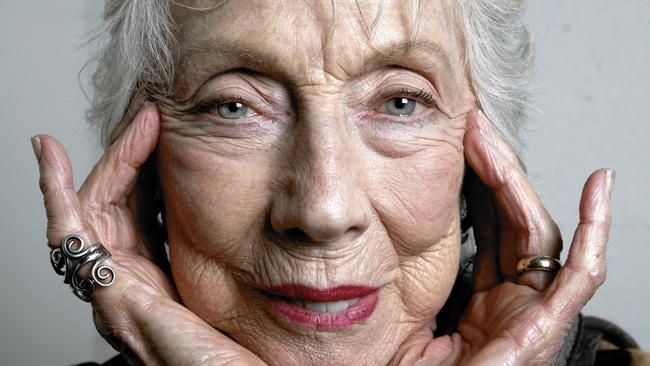 an older woman holding her hands up to her face