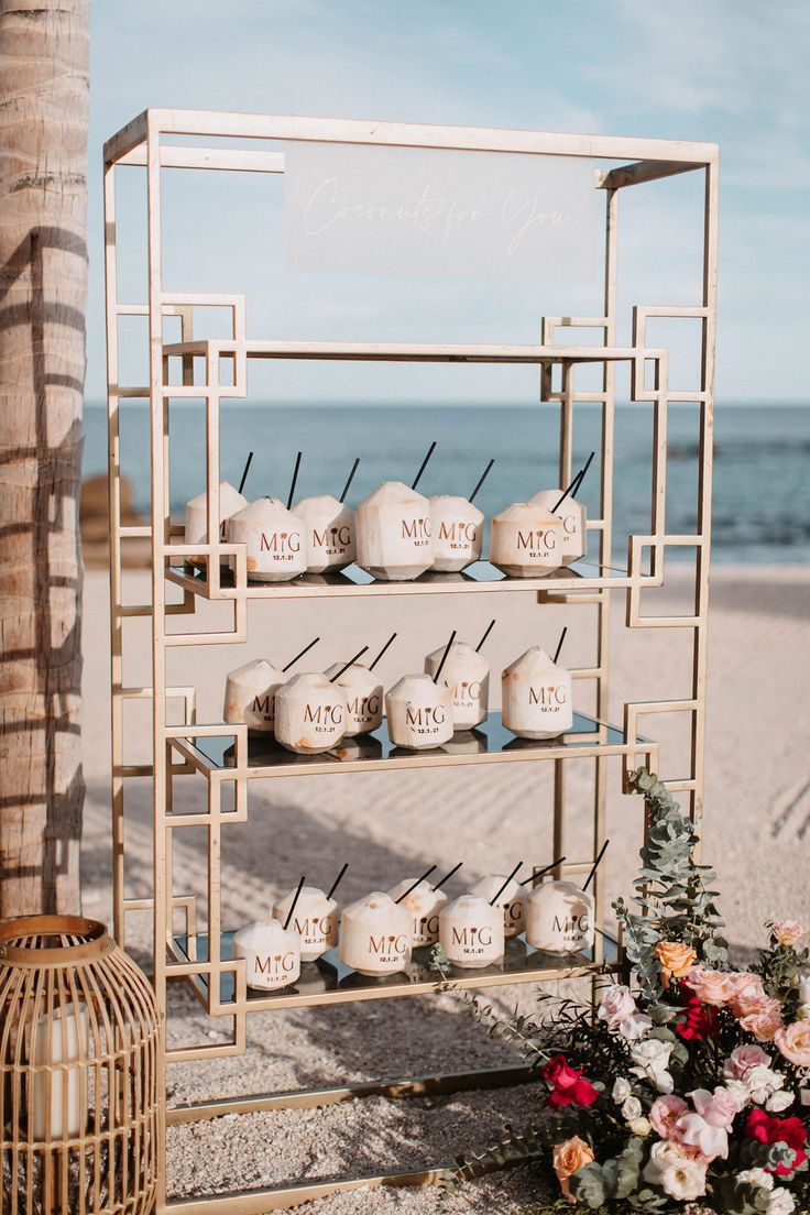 a wedding ceremony setup on the beach with candles and flowers in front of an ocean view