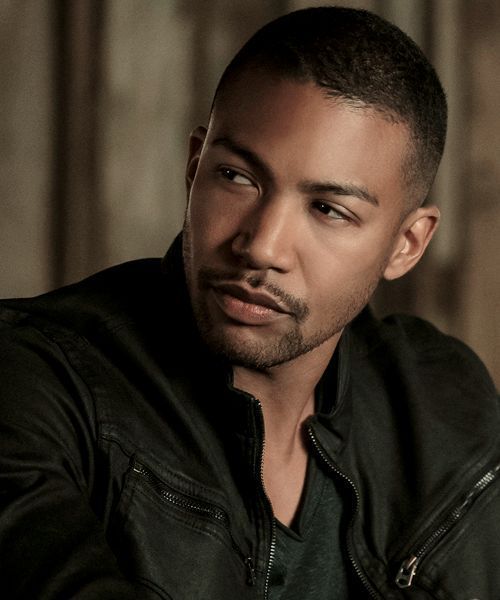 a close up of a person wearing a leather jacket and looking off to the side