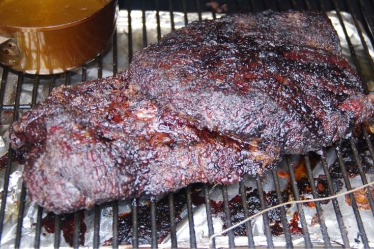 the steak is being cooked on the grill and ready to be grilled with sauce