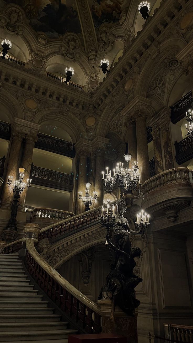 the chandeliers are hanging from the ceiling above the stairs in an ornate building