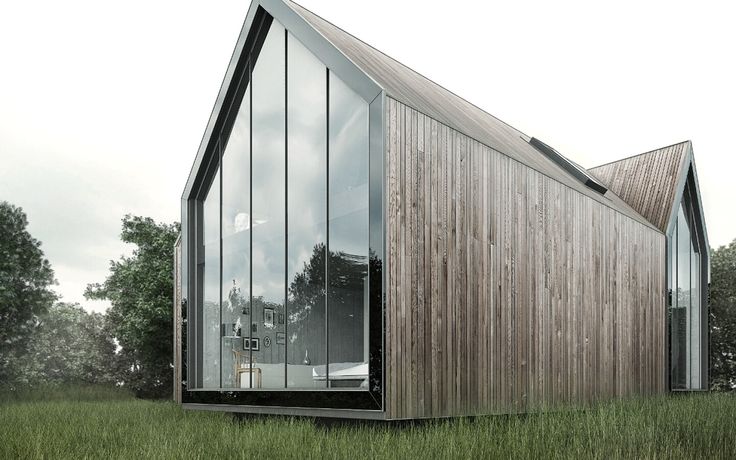 a wooden building sitting on top of a lush green field next to tall grass and trees