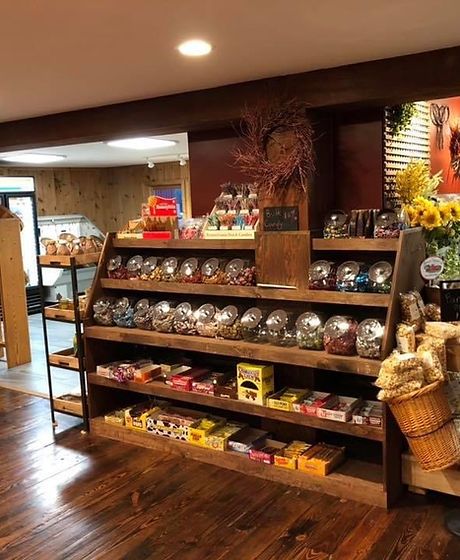 a store filled with lots of different types of food and decorations on display in front of the counter