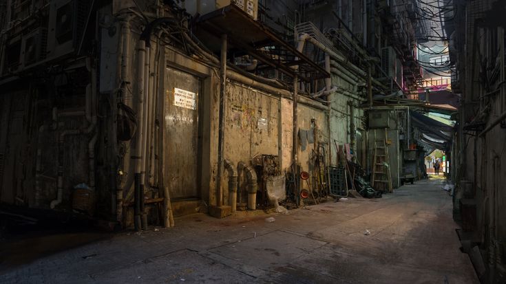 an alleyway with old buildings and scaffolding on the sides at night time