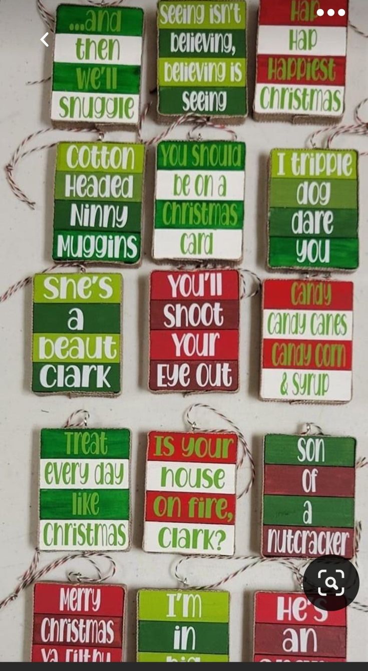 christmas ornaments hanging on a wall with words written in different colors and sizes, including red green and white