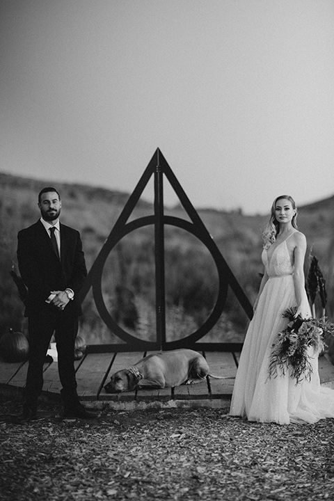 a man and woman standing next to each other in front of a hogwarts sign