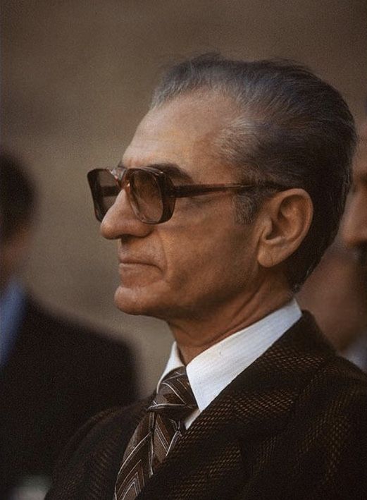 an older man wearing sunglasses and a suit